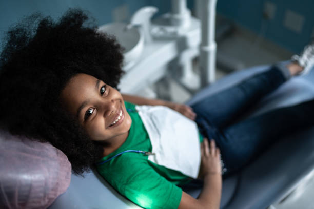 Portrait of a cute girl sitting on dentist’s chair
