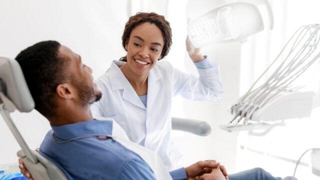 Female dentist turning on lamp before treatment